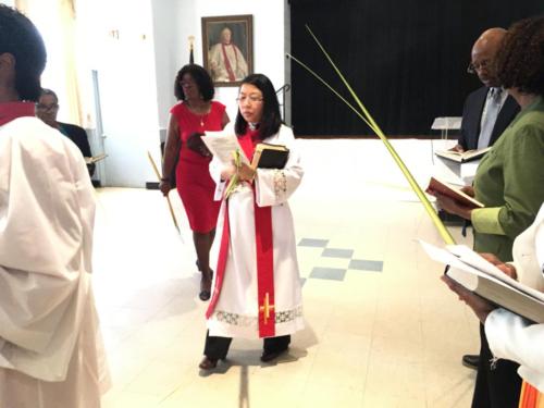 Reverend Ajung Sojwal and parishioners in Palm Sunday processional from Regan Hall